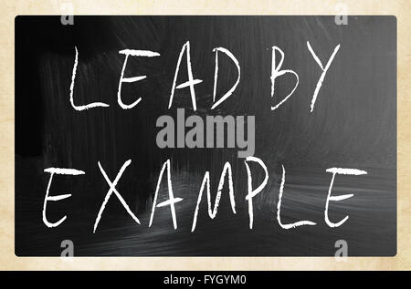 Lead by example handwritten with white chalk on a blackboard Stock Photo