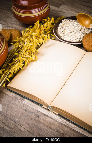 Oatmeal cookies and an old recipe book on the kitchen table Stock Photo