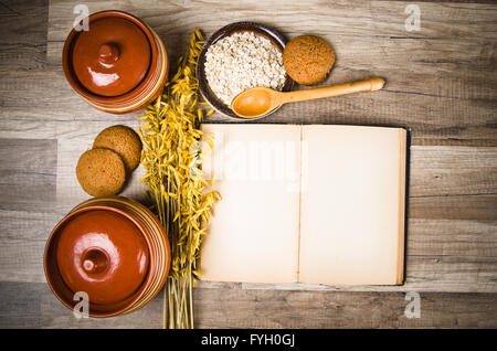 Oatmeal cookies and an old recipe book on the kitchen table Stock Photo