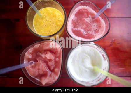 Top view of fresh fruit smoothie drinks on wooden table for healthy eating, assorted beverages summer concept. Stock Photo