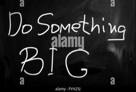 Do something big handwritten with white chalk on a blackboard Stock Photo