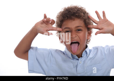 Young boy pulling a face and sticking his tongue out Stock Photo