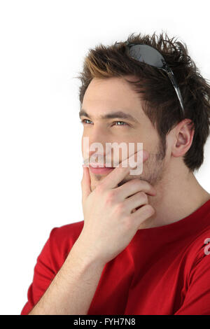 Pensive young man with sunglasses resting on his head Stock Photo