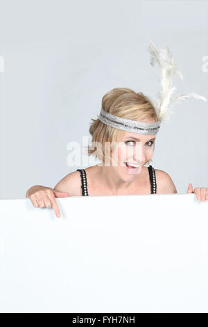 Woman in a flappers outfit with a board left blank for your message Stock Photo