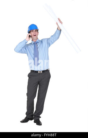 Young architect shouting down mobile telephone Stock Photo