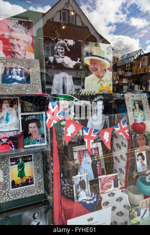 Collection of photographs of the Queen and Royal Family decorate a shop window in honour of the Queen's 90th birthday. Stock Photo