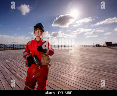A young womanl working on the decking of the newly restored Hasting Pier. Stock Photo
