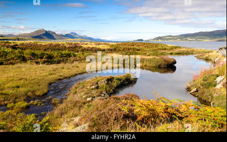 A small stream flows into the sea at Achadh Mor on the Isle of Skye in Scotland. Stock Photo
