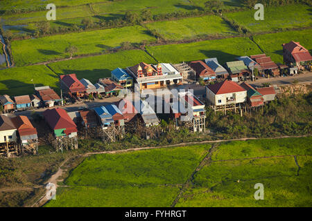 Village of stilt houses that are seasonally flooded, and rice fields, Phnom Krom, near Siem Reap, Cambodia - aerial Stock Photo