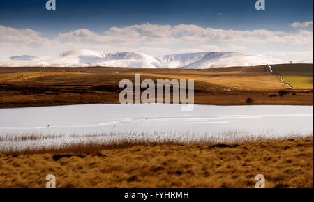 The snow-covered Howgill Fells of the Yorkshire Dales National Park provide the backdrop for the Sunbiggin Tarn.
