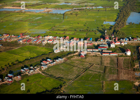 Village of stilt houses that are seasonally flooded, and rice fields, Phnom Krom, near Siem Reap, Cambodia - aerial Stock Photo