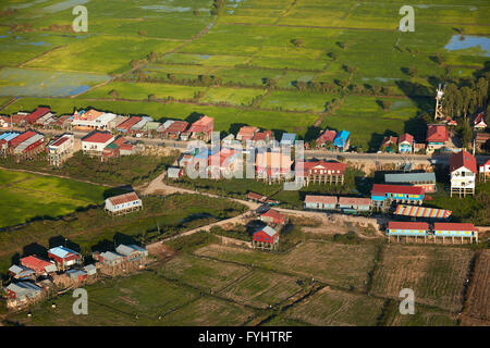 Village of stilt houses that are seasonally flooded, and rice fields, Phnom Krom, near Siem Reap, Cambodia - aerial Stock Photo