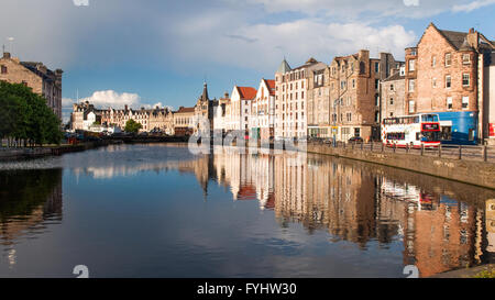 Houses and warehouses reflected in the Water of Leith in Edinburgh, Scotland. Stock Photo