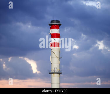 industrial chimneys on cloudy sky at sunset Stock Photo