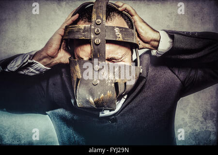 crazy, dangerous business man with iron mask and expressions Stock Photo