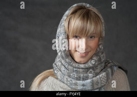 Portrait of woman on dark background wearing woolen accessories Stock Photo