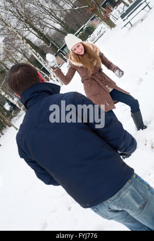 couple having a snowball fight Stock Photo