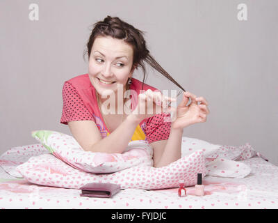 Girl cutting a lock of hair cuticle scissors Stock Photo