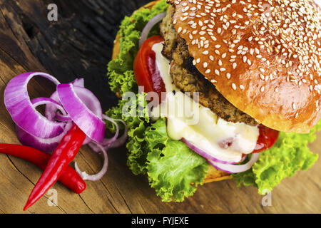 Yummy Hamburger with Veggies on Wooden Table Stock Photo