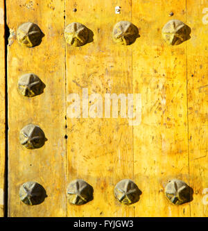 nail dirty stripped paint in the brown wood door and rusty yellow red Stock Photo