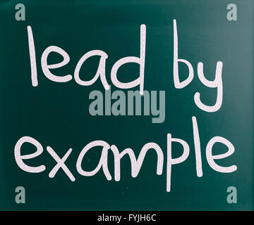 Lead by example handwritten with white chalk on a blackboard Stock Photo