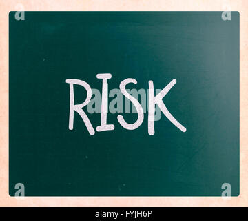 The word Risk handwritten with white chalk on a blackboard Stock Photo