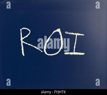The word ROI handwritten with white chalk on a blackboard Stock Photo