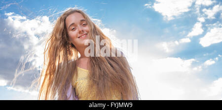 Portrait of happy woman smiling against clear sky Stock Photo