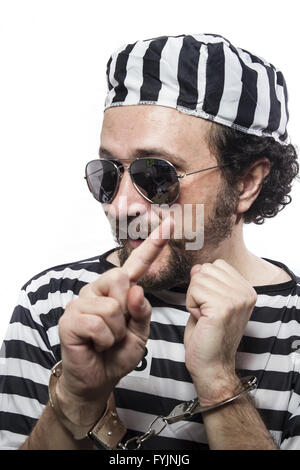 Funny man prisoner criminal with chain ball and handcuffs in studio isolated on white background Stock Photo