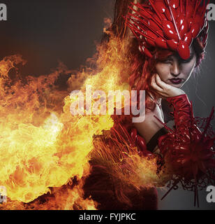 Girl on fire, Steampunk, beautiful woman dressed in red armor dragon scales Stock Photo
