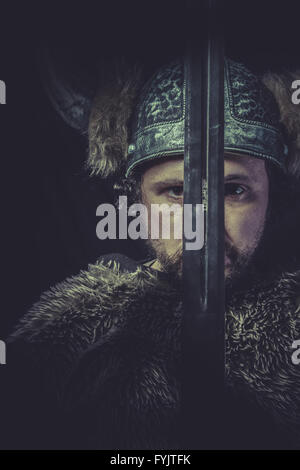War, Costume, Viking warrior with a huge sword and helmet with horns Stock Photo