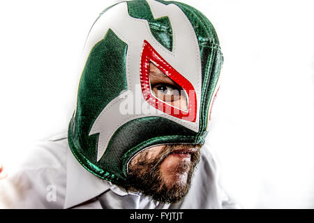 angry, aggressive businessman with Mexican warrior mask Stock Photo