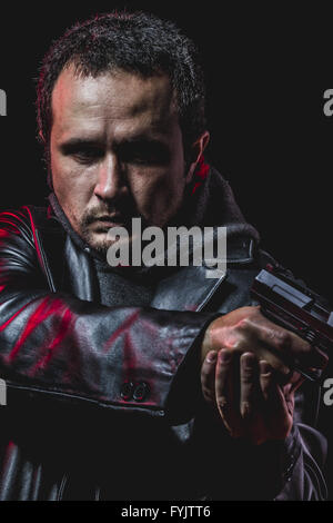 danger, thief with gun in hand. man in leather jacket Stock Photo