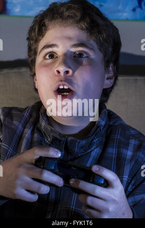 Happy. boy with joystick playing computer game at home. Stock Photo