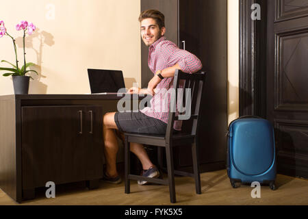 Young man using a laptop computer in a asian styled hotel room Stock Photo