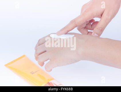 Woman pouring body lotion on hand on white background Stock Photo