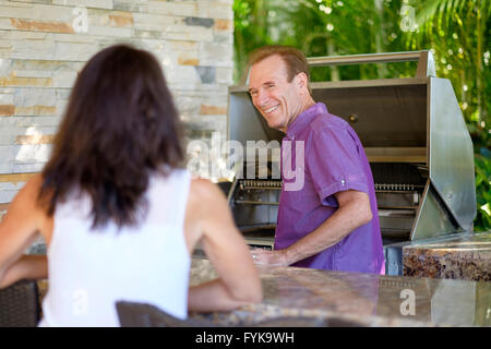 Senior man and woman enjoying a barbecue at their home in Mexico Stock Photo
