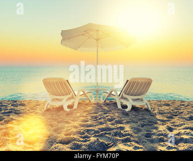 Beach chair and white umbrella on sand beach Stock Photo