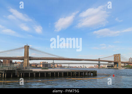 Wide angle view from riverside of Brooklyn bridge on blue sky with slightly cloud. Stock Photo