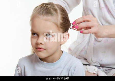 Mom braids hair six-year daughter Stock Photo