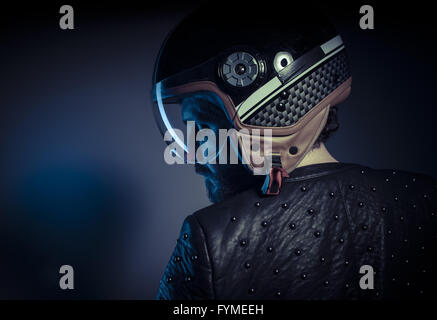 Travel, biker with motorcycle helmet and black leather jacket, metal studs Stock Photo