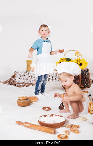 Little girl and funny boy wearing chef hats Stock Photo
