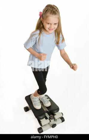 Six year old girl is engaged on a step simulator Stock Photo