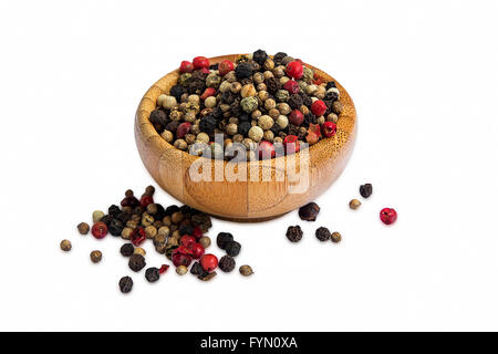 Red and black pepper seeds in wooden bowl isolated on white Stock Photo