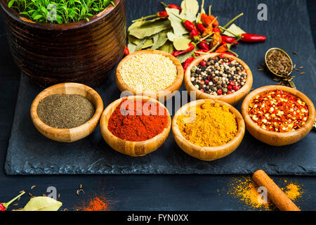 Ground spices and seeds in wooden bowls, spicy seasoning ingredients Stock Photo