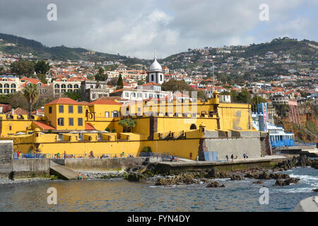 Fortress of Saint Tiago (Forte de Sao Tiago) on the seafront at Funchal in Madeira, Portugal. With people on promenade Stock Photo