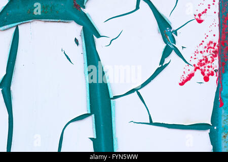 Abstract of peeling white paint on a turquoise background with red splatters and rust  marks. Stock Photo