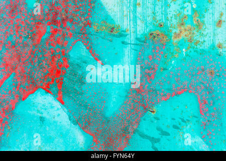 Abstract of red paint splatters and rust marks on a turquoise background . Stock Photo