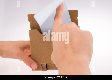 Hand reaches paper holder stand on white background Stock Photo