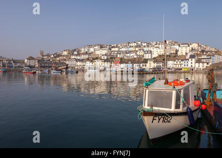 A postcard view of a boat at Brixham harbour. The morning sun shines on the harbour in Devon, South West England Stock Photo